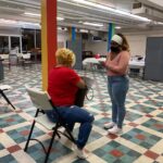 In the final step before getting vaccinated, a volunteer explains what will happen during and after the shot. (Photo: Olivia Smucker)