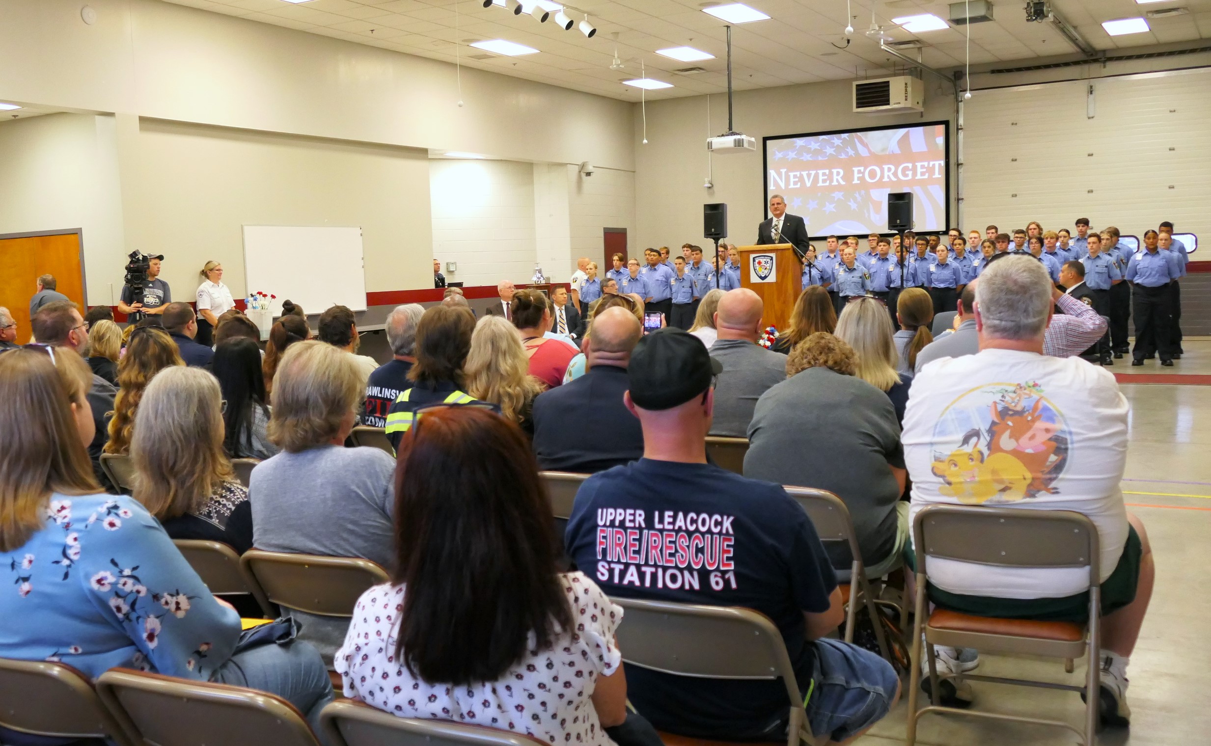 Public Safety Training Center Director Todd Kirkpatrick, at podium, speaks following the readout of names and laying of flowers. (Photo: Tim Stuhldreher)